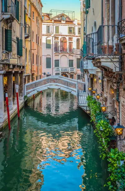 Photo of Bridge over narrow canal in Venice.