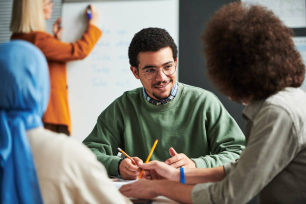 istock Happy young man in eyeglasses communicating with another student 1443305409