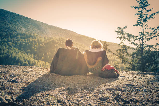 Couple sitting and watching the magnificent view from mountain Ymittos near Athens, Greece