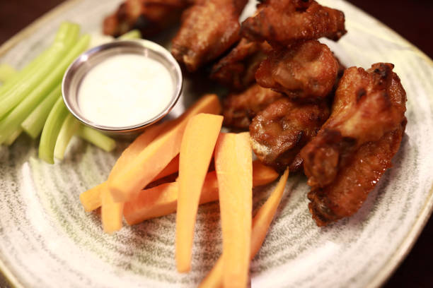 istock Fried chicken wings with vegetable sticks on plate 1443307982