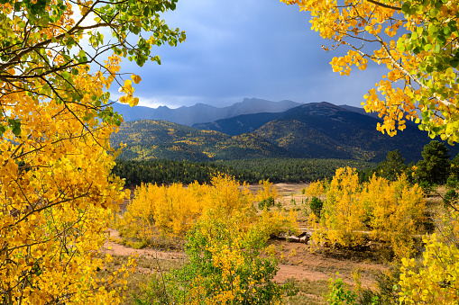 Mountain range in Pike Peak, Colorado Springs in autumn colors with dramatic clouds.