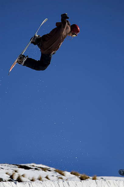 Snowboarder jumping through the air stock photo