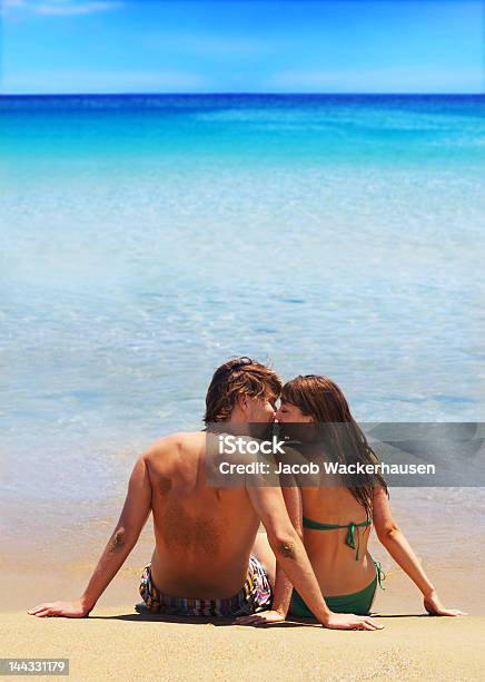 Couple Sitting On The Beach Stock Photo - Download Image Now - 20-24 Years, 20-29 Years, Adult