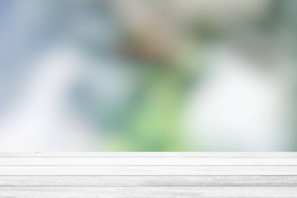 istock White Wood Table with Blurred Green Garden Background, Suitable for Product Display and Business Concept. 1443314976