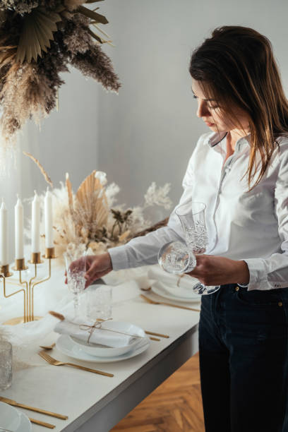istock Beautiful Woman Setting Up Christmas Dinner Table At Home 1443318104