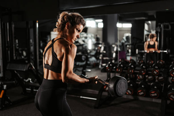 istock Young Woman Training With A Barbell At The Gym 1443318152