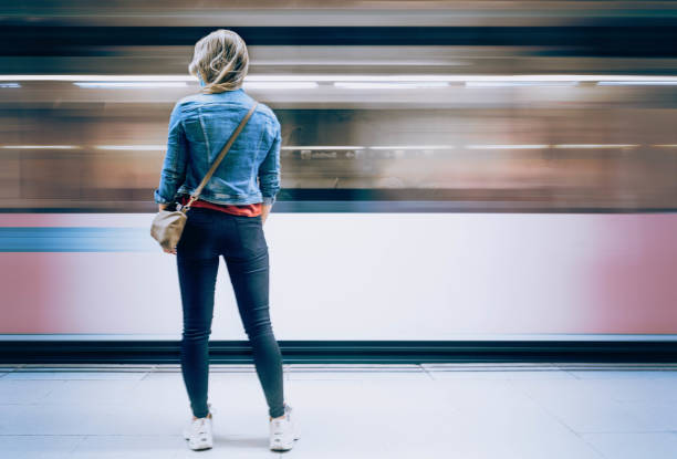 young woman waiting for subway stock photo