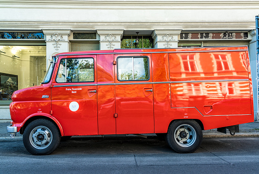 Bucharest, Romania, 5 June 2021 Old retro vivid orange Volkswagen classic minivan or microbus parked a street in a sunny summer day