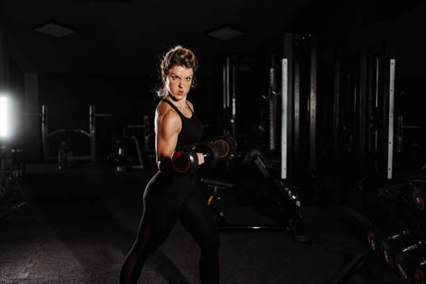 istock Young Woman Training With Dumbbells At The Gym 1443320681