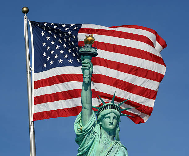 istock Statue of Liberty with a large American flag behind her 144332135