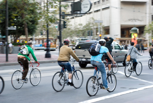 Environmentally conscious bikers in traffic in San Francisco, California. Motion blur on the subjects - faces unrecognizable.