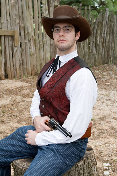 istock Fancy Dressed Cowboy Posing with Gun in Farm Yard 144332375