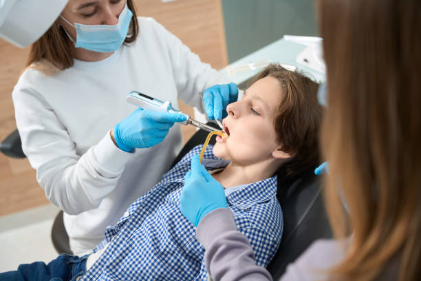 женщина-стоматолог на рабочем месте лечит зуб мальчика - occupation group of people dentist child стоковые фото и изображения