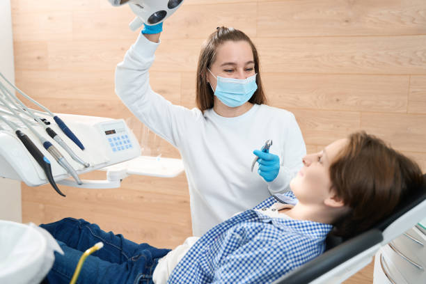 istock Friendly female dentist encourages a young patient before tooth extraction 1443325066