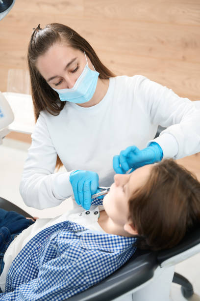 istock Dentist surgeon removes a tooth to boy with special tool 1443325078