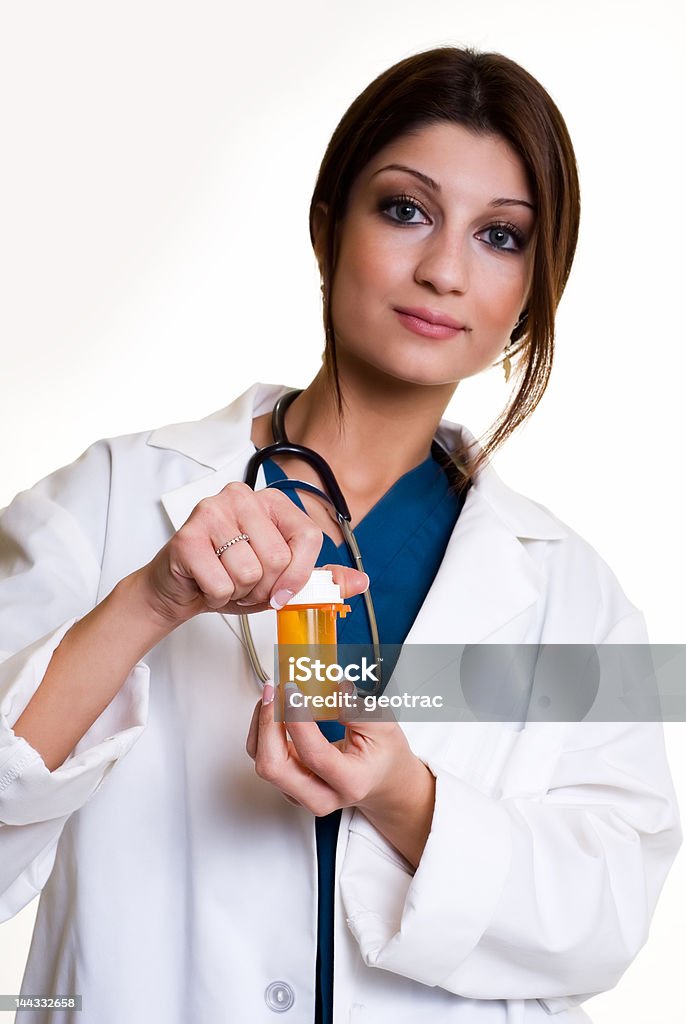 Pharmacist Confident pretty woman healthcare worker wearing medical uniform holding a medicine bottle standing on white 20-29 Years Stock Photo