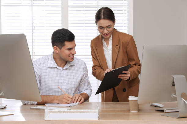 istock Businesswoman helping intern with work in office 1443327148
