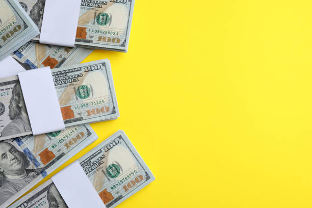 istock Dollar banknotes on yellow background, flat lay. Space for text 1443327305