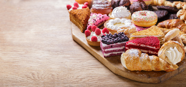 Sweet dessert. Various piece of cakes, muffins and cookies on wooden board