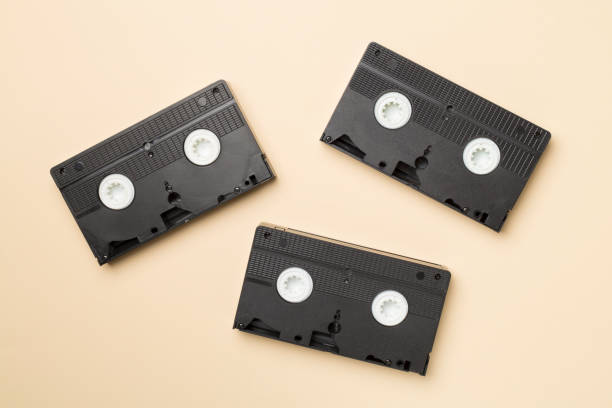 istock Old analog tape VHS cassettes on color background, top view 1443332510