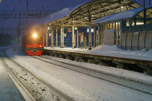 Electric train arrives on the station in the blizzard in the Moscow region stock photo