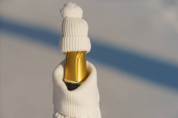 Сhampagne bottle formed as a human figure dressed in warm snow-white winter clothes. stock photo