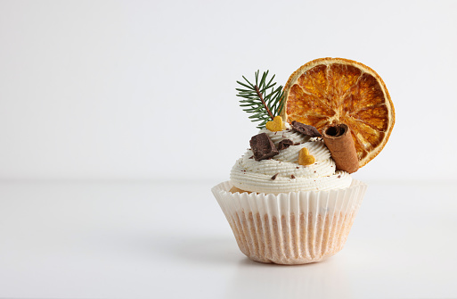 Tasty Christmas cupcake with cream and decor on white background, space for text
