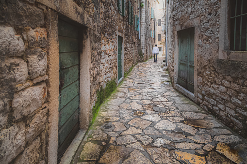 Quaint, narrow, cobblestone lane in the historic, medieval old town of Sibenik, Croatia.