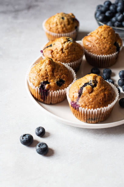 istock Blueberry muffins  served on a white plate on a marble background. 1443334075