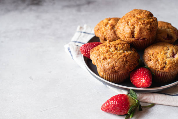 istock Strawberry muffins with berries served on a plate on a white marble background. 1443334077