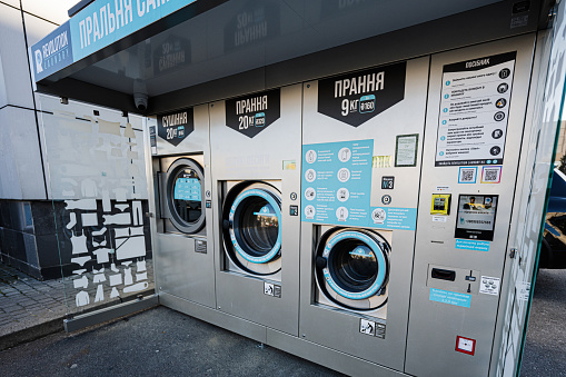 Lviv, Ukraine - October 09, 2022: Washing machine and dryer self service laundry, laundromat.