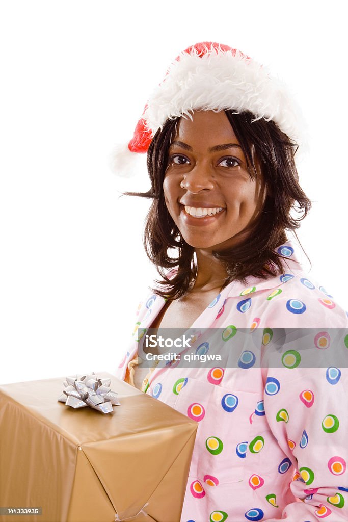 Sorridente donna nera pigiama Cappello da Babbo Natale con un regalo isolato sfondo - Foto stock royalty-free di 20-24 anni