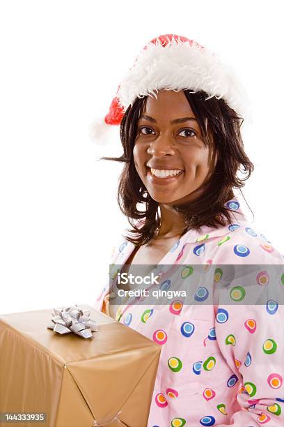 Улыбающаяся Черный Женщина Пижама Santa Hat Holding Gift Изолированный Фон — стоковые фотографии и другие картинки 20-24 года