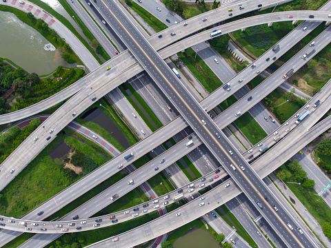 Aerial drone photo of a road with multiple levels of intersection in a densely populated area.