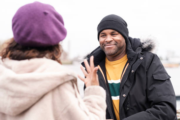 istock Deaf man is smiling and looking at her deaf friend who is using sign language. 1443344036