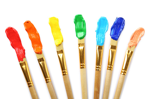 Brushes with colorful paints and strokes on white background, top view