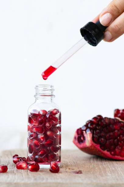 istock Woman Dripping Pomegranate Seed Oil 1443347673