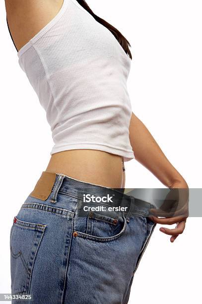 A Young Woman Holding Bigger Fitted Pants Stock Photo - Download Image Now - Dieting, Jeans, Women