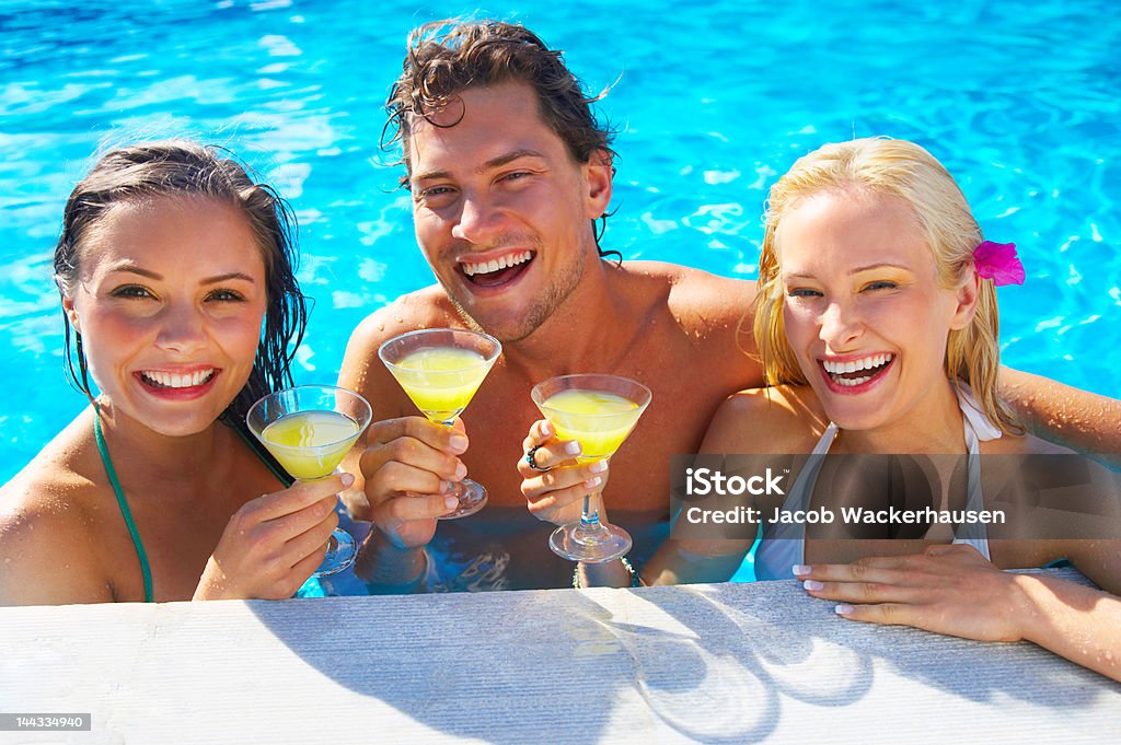 Sus amigos mientras disfruta de cócteles en la piscina - Foto de stock de Adulto libre de derechos