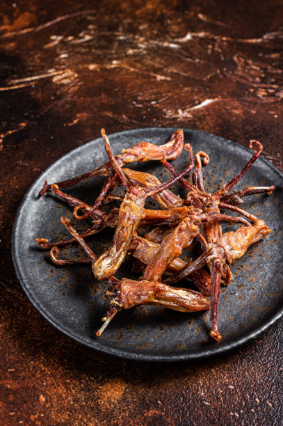 istock Spicy Dip fried duck tongue. Dark background. Top view 1443349468