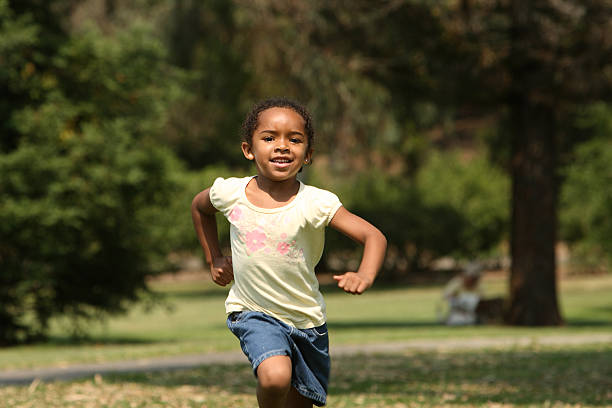 istock Young girl running outside in a park 144335106