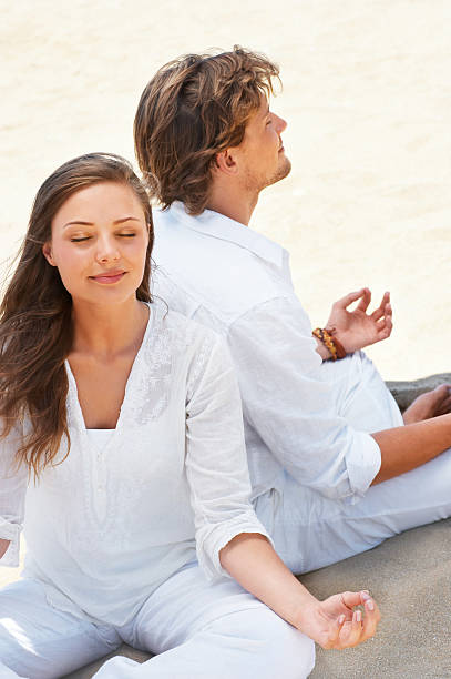 istock Couple meditating on the beach 144335222