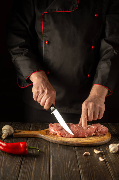 istock A professional chef cuts raw veal meat on a cutting board before baking. Asian cuisine. Cooking delicious food in the kitchen. 1443352952
