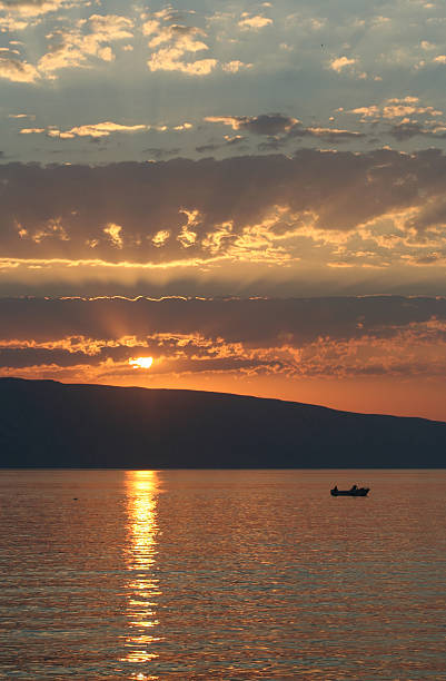 istock Sunset on the sea with a boat 144335630