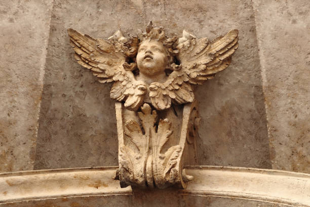 Angel in Rome Close up of a small angel carved in the top, internal part of the portal of the church of Santi Vincenzo e Anastasio a Trevi,  a Baroque church rebuilt in 1650 in Rome. winged cherub stock pictures, royalty-free photos & images