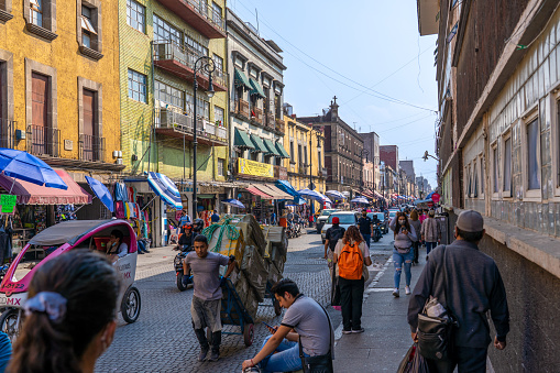 Mexico City Mexico - February 18 2022: A busy street with stores and markets filled with people in the Central district of Mexico City