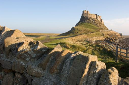 A winters scene of the historic castle on Holy island dominating the skyline on this flat area of North east coastline.