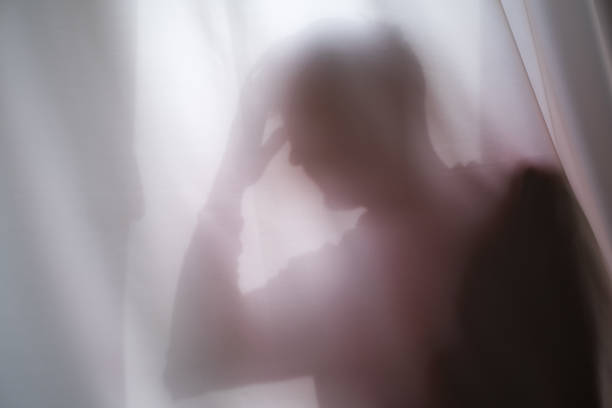 istock Depressed Man with mantal problems hiding above the curtain. 1443365584