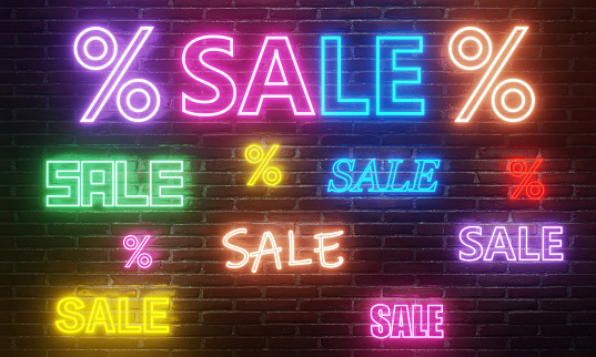 Sale concept. Sale neon signs on brick wall. Neon lighting and colored sale words and percentage signs on brick wall background