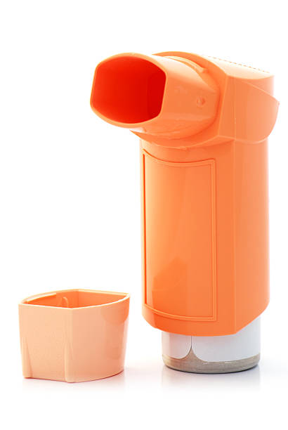 Orange asthma inhaler and hood on white background